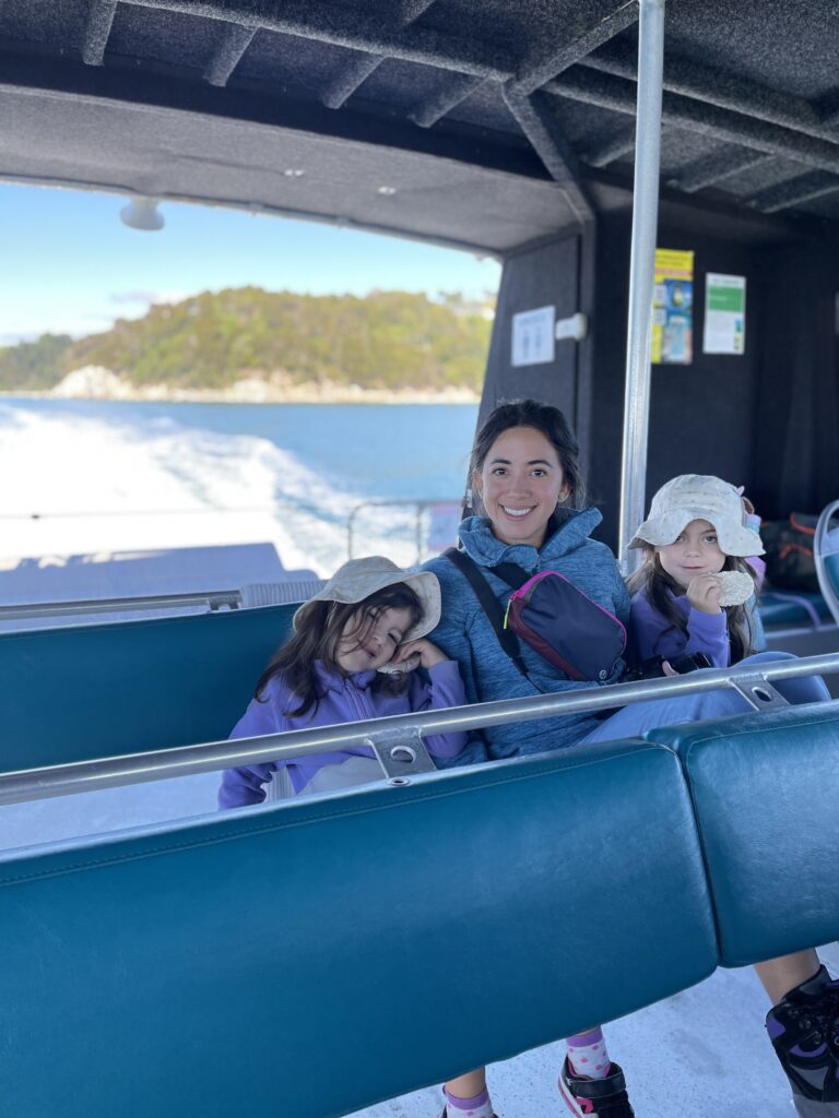 2 small girls and 1 woman sitting on the Abel Tasman Water Taxi on the way to Awaroa Lodge