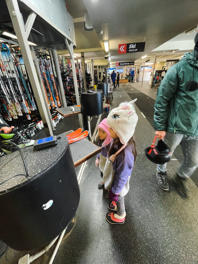 two little girls getting skis fitted at the cardrona ski field rental area