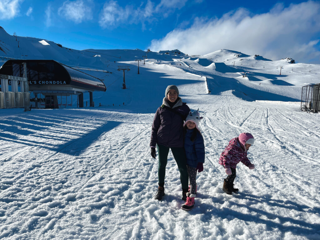 mother and daughters walking around on empty cardrona ski field