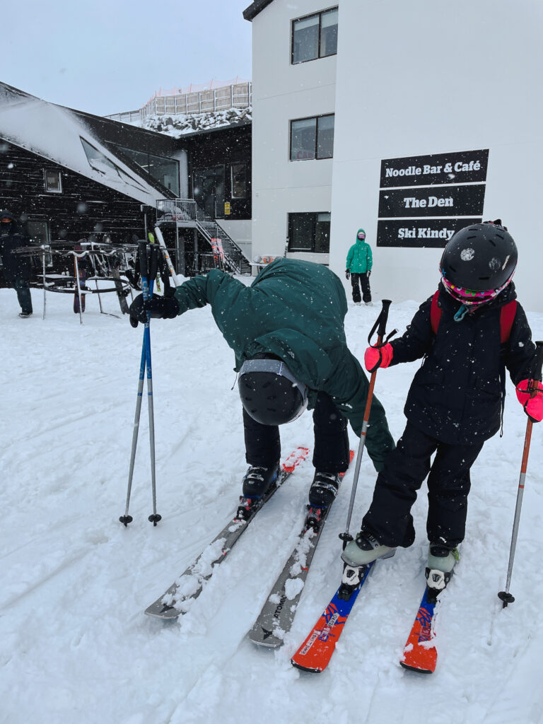 Dad helping daughter with skis at the cardrona ski field