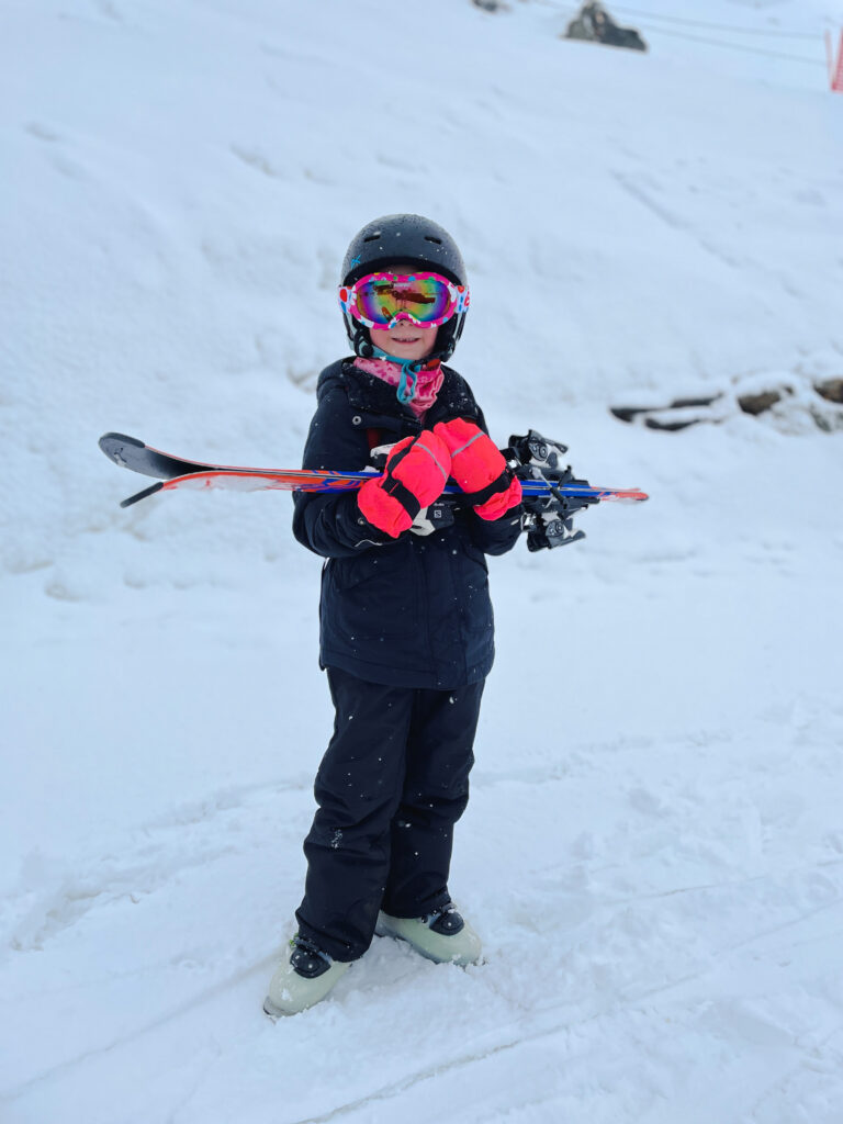 little girl in ski gear waiting for youth lessons at a New Zealand ski resort