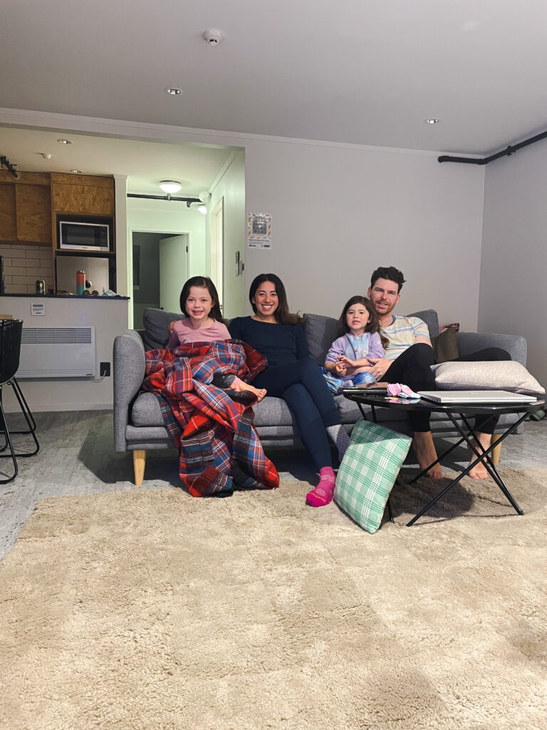 family smiling and relaxing inside apartment at the cardrona alpine resort