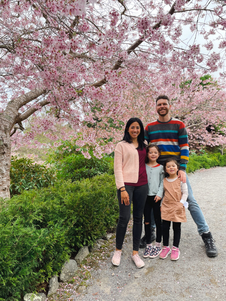 family standing below flowering cherry blossoms during a wellington day trip